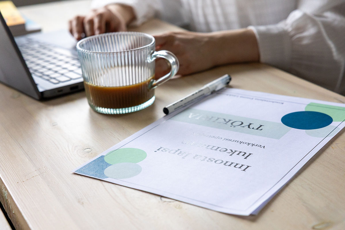 Innosta lapsi lukemaan -verkkokurssin työkirja pöydällä.